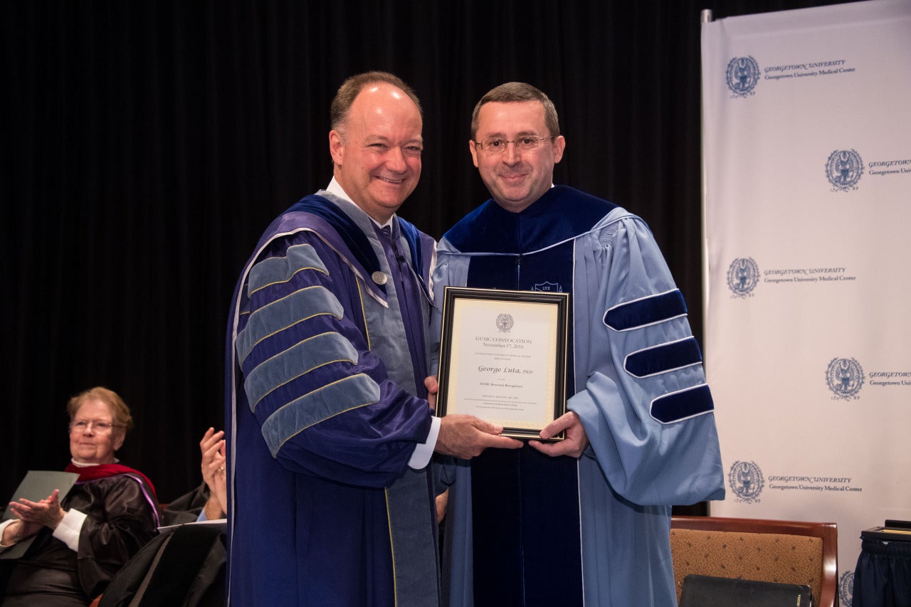 Georgetown University President John J. DeGioia presents the Research Recognition Award to Dr. George Luta.